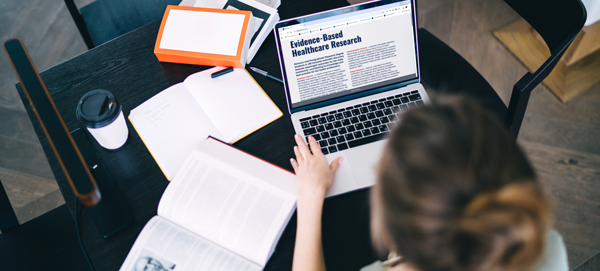 Clinician used a laptop and some reference texts to do some evidence-based healthcare research