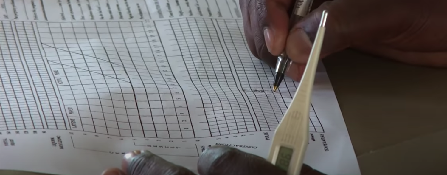 Healthcare worker filling out the partogram