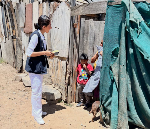 A healthcare worker visits a family at their home in a less affluent area