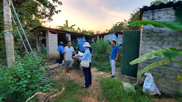 A scientist in the field talks to farmers