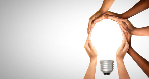 Several hands forming a light globe shape representing the bridge between policymakers and evidence for better healthcare