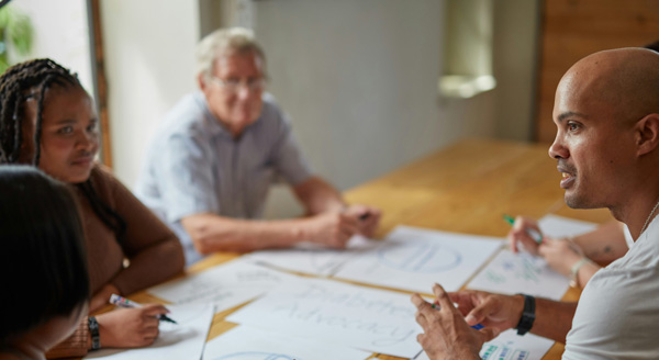People sit around a table discussing health technology assessments