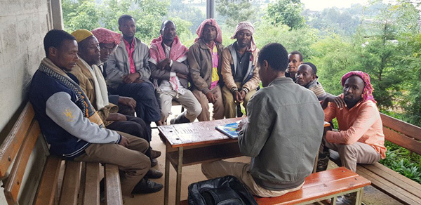 A religious leader talks to men about institutional delivery of babies in rural Ethiopia