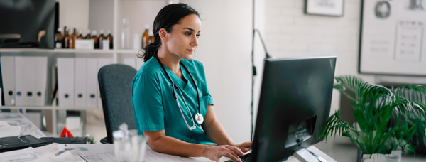 A clinician sits in front of a computer studying MSc in Evidence-Based Future Healthcare