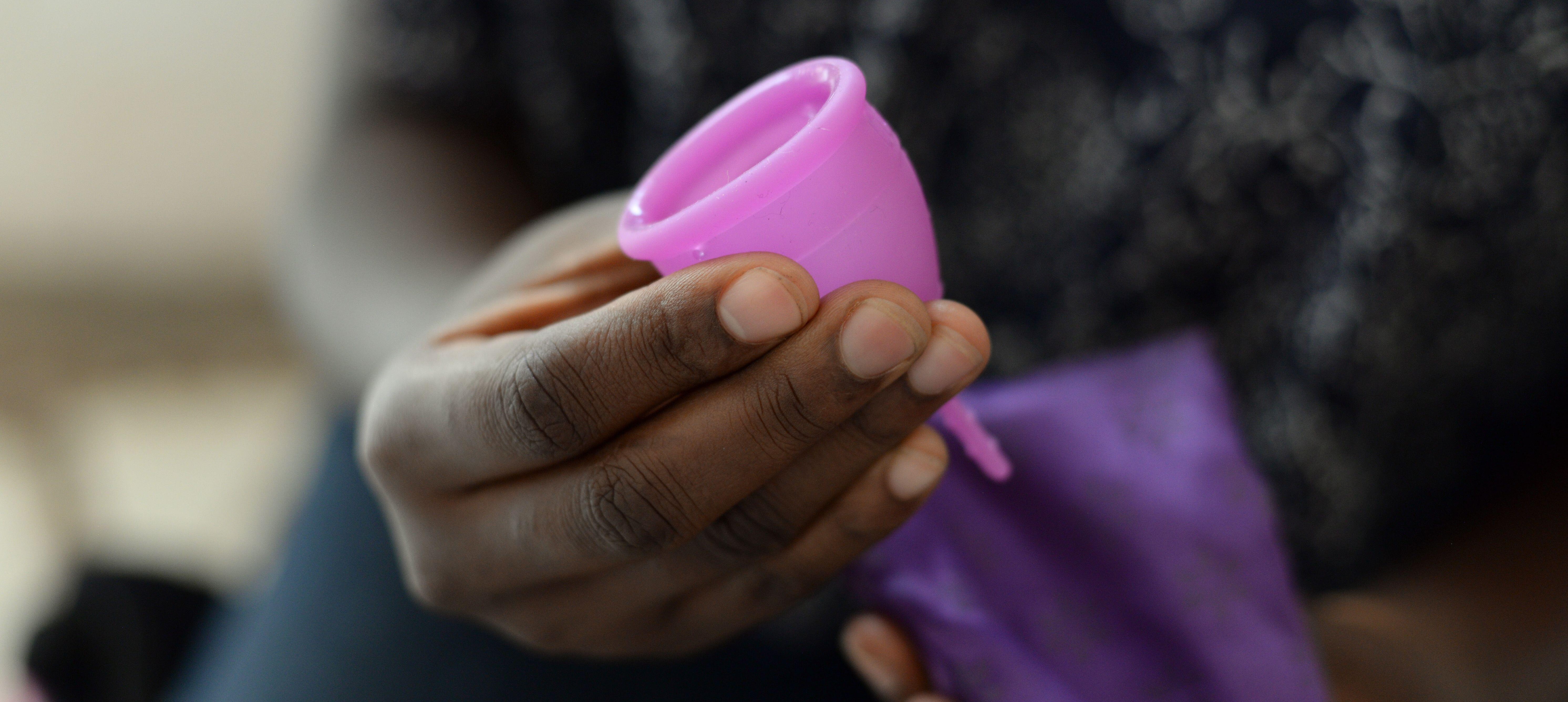 Woman holds menstrual cup