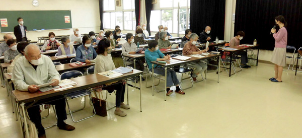 Several people attend a workshop about support of the elderly via mobile apps in a classroom setting
