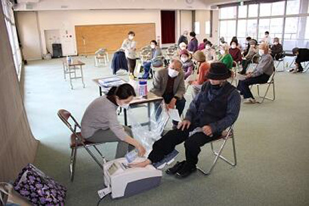 Elderly people wait while someone receives a bone density screening.