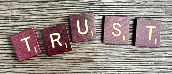 Scrabble letters spelling the word 'Trust'
