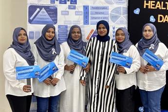A group of women at an event hold signs for World EBHC Day